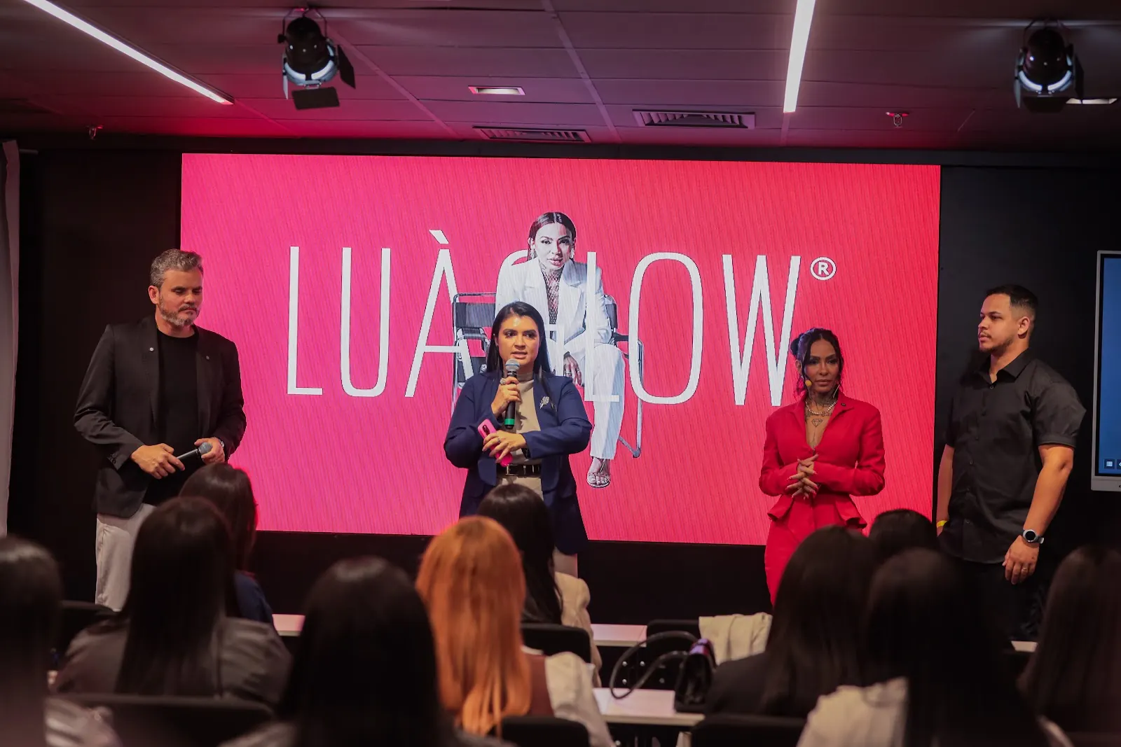 Palco do evento com telões vermelhos Lua Glow e plateia