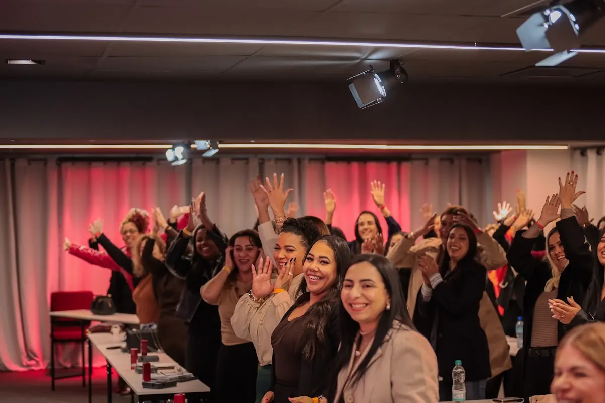 Plateia de mulheres com as mãos levantadas durante o evento